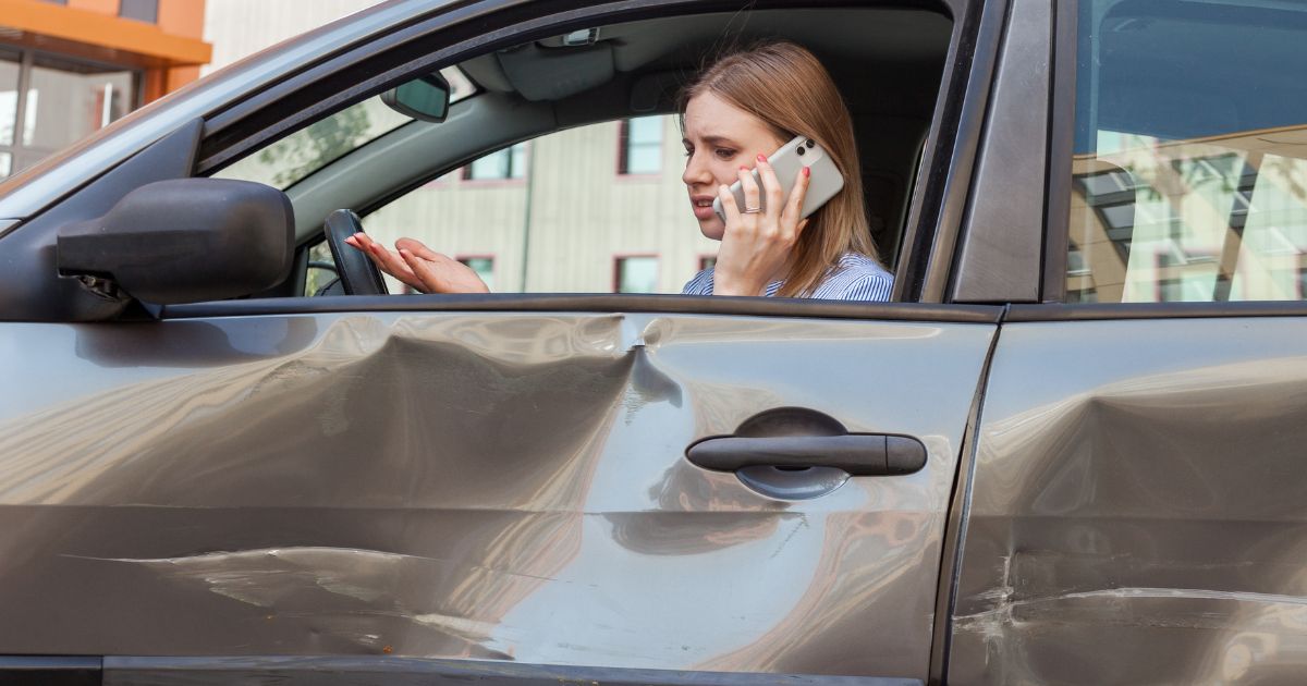 young woman calling the police after a car accident